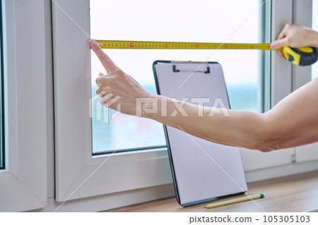 Woman measuring window with tape measure, tailoring service Woman measuring window with tape measure, tailoring service 105305103