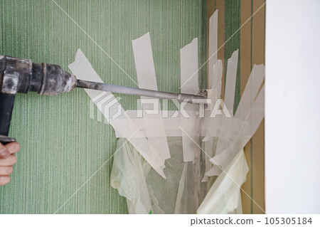 Drilling the wall with crown nozzle and collecting the dust in a bag  105305184