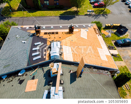While repairing roof of apartment building, old shingles replaced plywood and new shingles were installed. 105305693