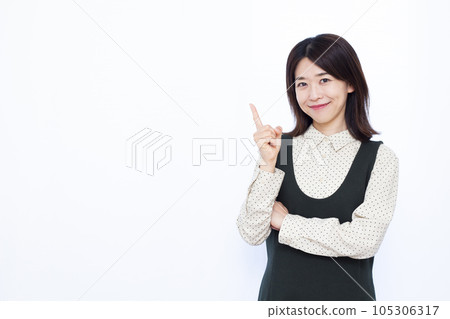 A woman in her thirties who raises her index finger in front of a white background A woman in her thirties who raises her index finger in front of a white background 105306317