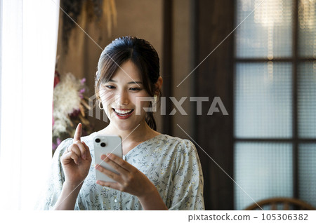 一位女士在咖啡館操作智慧型手機 105306382