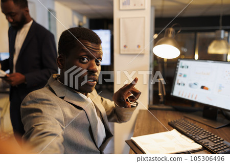 Businessman showing financial graph to remote coworkers discussing company strategy during online videocall meeting conference. Colleagues working late at night at marketing project 105306496