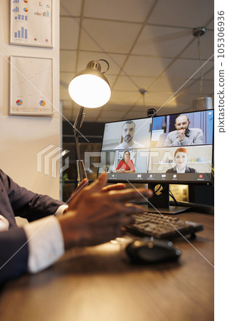 Entrepreneur discussing financial statistics with remote team during online videocall meeting conference. Diverse corporate employees working overhours at company growth report in startup office Entrepreneur discussing financial statistics with remote team during online videocall meeting conference. Diverse corporate employees working overhours at company growth report in startup office 105306936