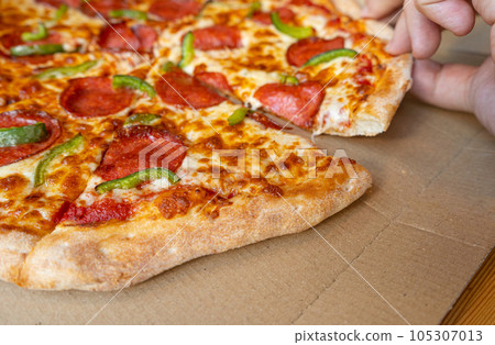 Pepperoni Pizza in Cardboard Delivery Box Closeup, Salami Pizza with Green Paprika, Chili Pepper Pepperoni Pizza in Cardboard Delivery Box Closeup, Salami Pizza with Green Paprika, Chili Pepper 105307013