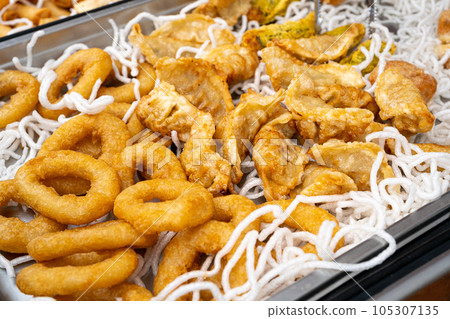 Deep Fried Gyoza Chinese Dumplings and Squid Rings, Fried Vegetable Jiaozi Street Food, Chicken Momo Pile Deep Fried Gyoza Chinese Dumplings and Squid Rings, Fried Vegetable Jiaozi Street Food, Chicken Momo Pile 105307135