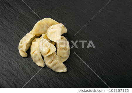 Gyoza Chinese Dumplings, Steamed Vegetable Jiaozi, Chicken Momo Pile, Asian Gyoza Group on Black Stone Gyoza Chinese Dumplings, Steamed Vegetable Jiaozi, Chicken Momo Pile, Asian Gyoza Group on Black Stone 105307175
