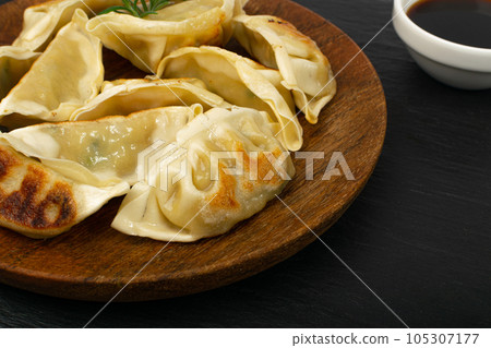 Gyoza Chinese Dumplings on Wood Plate, Fried Vegetable Jiaozi Macro, Chicken Momo Pile, Asian Gyoza Closeup Gyoza Chinese Dumplings on Wood Plate, Fried Vegetable Jiaozi Macro, Chicken Momo Pile, Asian Gyoza Closeup 105307177