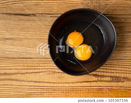 Two Broken Eggs in Bowl Isolated, Raw Yolk and White, Fresh Broken Organic Chicken Eggs 105307336