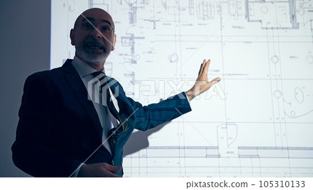 A silhouette of a man explaining a strategy using a projector 105310133