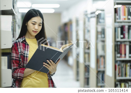 University students reading books in library for research. University students reading books in library for research. 105311414