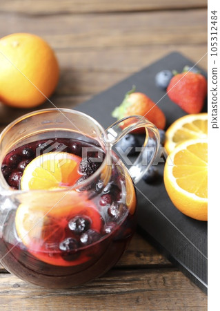 A glass pot filled with herbal tea with plenty of fresh fruit 105312484