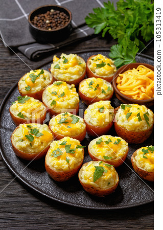 baked stuffed red potatoes on black plate 105313419