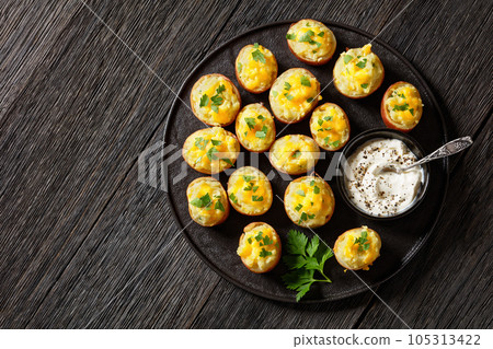 baked stuffed red potatoes on black plate baked stuffed red potatoes on black plate 105313422