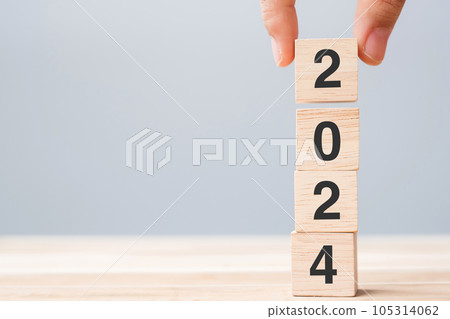 hand holding wooden cube block with 2024 text on table background. Resolution, plan, review, goal, start and New Year holiday concepts 105314062