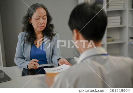 A businesswoman is talking about resigning and trying to compromise with a male employee A businesswoman is talking about resigning and trying to compromise with a male employee 105319904