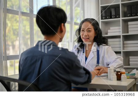 A female doctor is giving a consultation on a treatment plan after surgery to a male patient 105319968