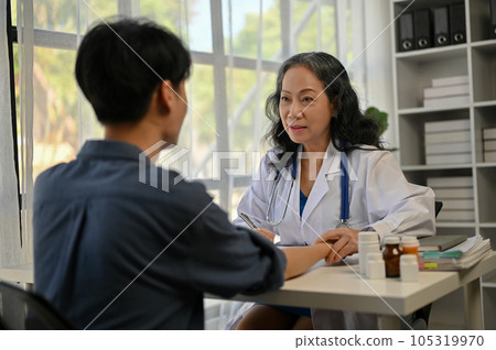 A professional Asian doctor is giving a consultation on a treatment plan to a male patient 105319970