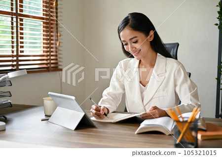 An attractive Asian businesswoman working on her business tasks at her desk 105321015