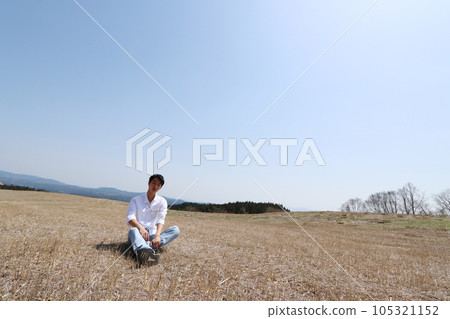A man sitting on the vast Kyushu prairie 105321152