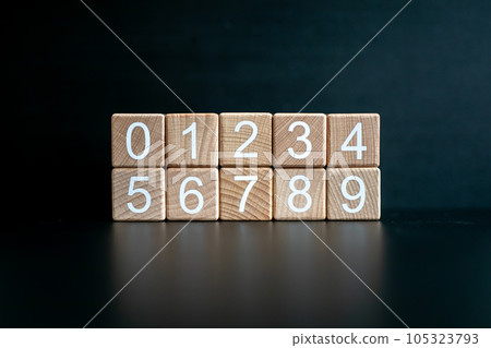 Several wooden blocks arranged from 0-9 horizontally against a black background. Several wooden blocks arranged from 0-9 horizontally against a black background. 105323793