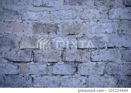 A gray wall of large blocks. Grey cinder block. The wall of an industrial building. A gray wall of large blocks. Grey cinder block. The wall of an industrial building. 105324484