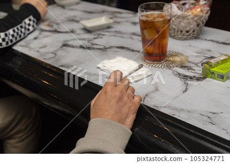 一個男人在小吃櫃檯抽煙的手 一個男人在小吃櫃檯抽煙的手 105324771