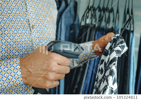shop assistant uses a barcode scanner in a clothes shop using shop assistant uses a barcode scanner in a clothes shop using 105324811