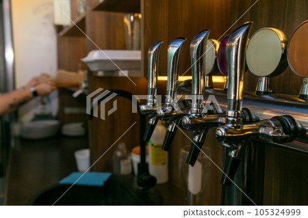 Chromed taps for draft beer in a modern bar. Chromed taps for draft beer in a modern bar. 105324999