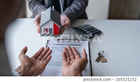 Real estate broker agent presenting and consult to customer to decision making sign insurance form agreement, home model, concerning mortgage loan offer for and house insurance Real estate broker agent presenting and consult to customer to decision making sign insurance form agreement, home model, concerning mortgage loan offer for and house insurance 105325252