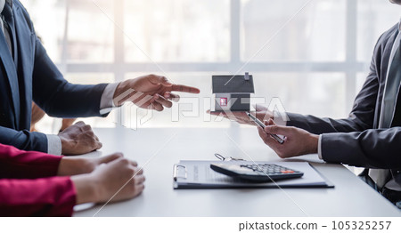 Modern office meet realtor young couple sitting at desk discuss new house plan first home 105325257