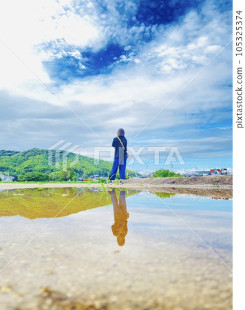 一個女人獨自站在雨後的天空 一個女人獨自站在雨後的天空 105325374