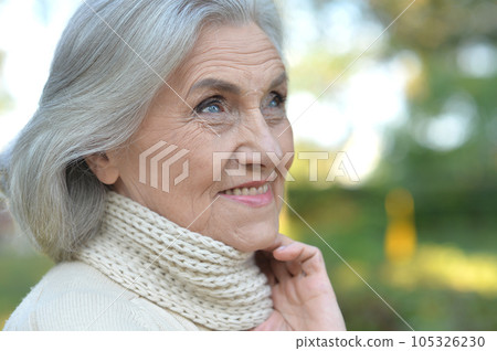 Close up portrait of happy older woman standing outside 105326230
