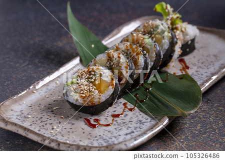 Sushi, delicious Japanese cuisine. Rolls of delicious sushi on a plate Sushi, delicious Japanese cuisine. Rolls of delicious sushi on a plate 105326486