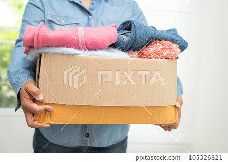 Donation box with used clothes at home to support help for poor people in the world. 105326821