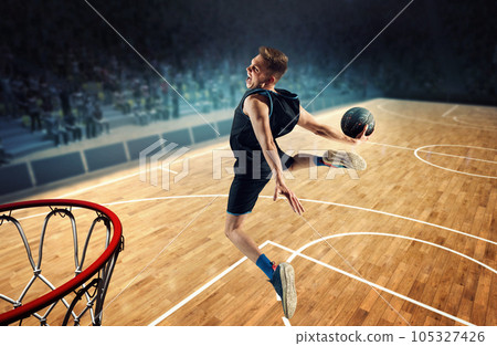 Top view image of emotional man, basketball player in motion during match, jumping, throwing ball into basket. 3D stadium 105327426
