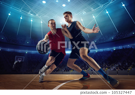 Tense game. Competitive young men, basketball players in motion during match, game playing at 3D arena with flashlights 105327447