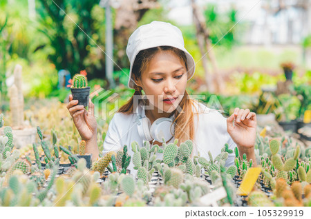 Young women doing hobbies taking care of plants, watering, shoveling flowers. In the garden during the break from work 105329919