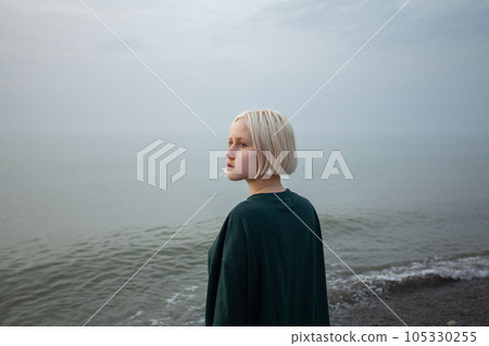 Attractive young woman with short hair standing on the sea coast 105330255