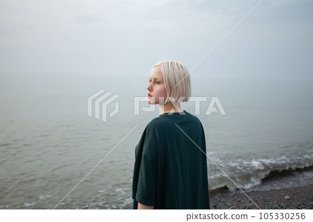 Portrait of young adult blonde woman with short bob haircut outdoor 105330256