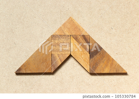 Wooden tangram in arrow shape on wood background Wooden tangram in arrow shape on wood background 105330784