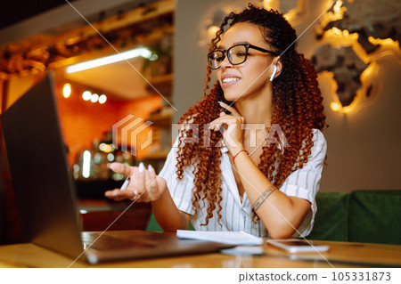Portrait of African American woman sitting at cafe having video call on laptop computer. 105331873