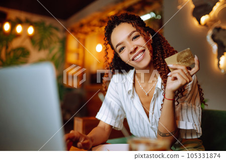 Young woman sitting at cafe making online shopping, using credit card and laptop. Online shopping 105331874
