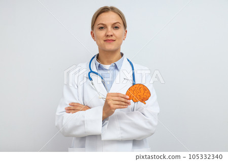 A young female doctor holds a paper human brain in her hand A young female doctor holds a paper human brain in her hand 105332340