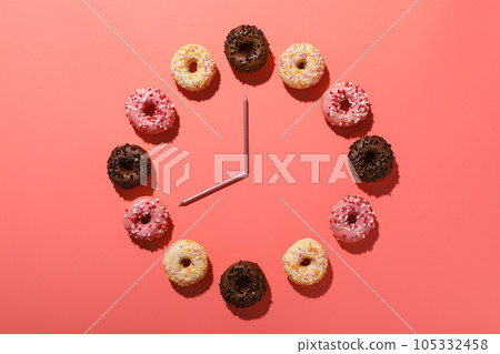 Donuts clock and candles on pink background, top view Donuts clock and candles on pink background, top view 105332458