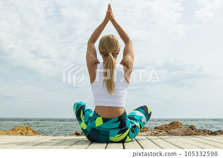 The girl does yoga in nature, near the sea 105332598
