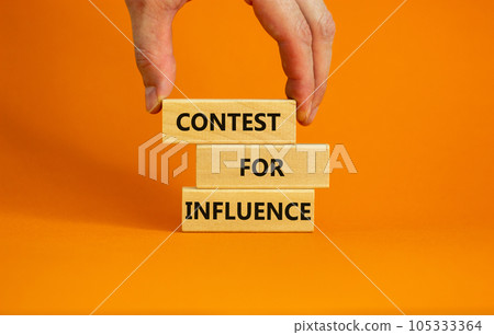 Contest for influence symbol. Wooden blocks with words 'Contest for influence'. Beautiful orange background, businessman hand. Business, contest for influence concept, copy space. 105333364