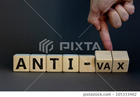 Anti-vax symbol. Doctor turns cubes with words 'anti-vax'. Beautiful grey background. Copy space. Business, medical covid-19 vaccination or anti-vax concept. 105333402