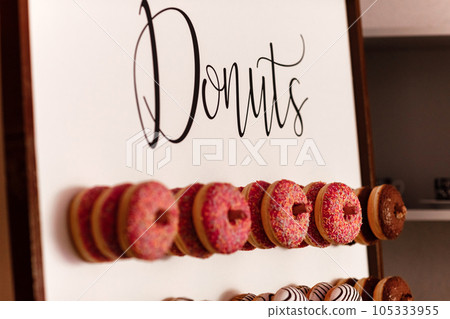 wedding chocolate donuts for guests. festive concept. sweets on a wedding day. wedding donuts. A yummy donut wall. wedding chocolate donuts for guests. festive concept. sweets on a wedding day. wedding donuts. A yummy donut wall. 105333955