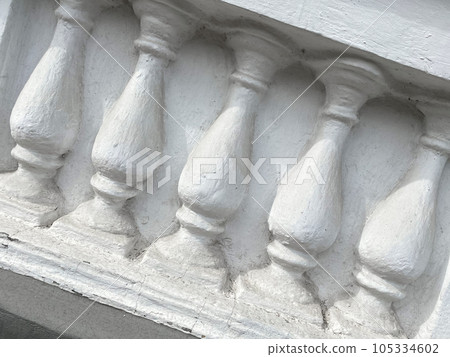 Old white bas-relief of balustrade on the building. Decorative structure. Set of balusters 105334602