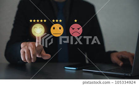 Businessman using a virtual screen to assess customer satisfaction and service quality by pointing to the highest level smiley face icon, ensuring positive feedback 105334924